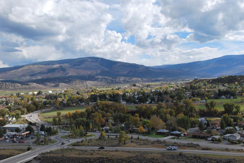 View of town of gypsum from the north, mountains in the background, interstate and vehicles in the foreground 